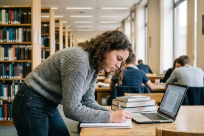 Jeune femme concentrée prenant des notes dans une bibliothèque